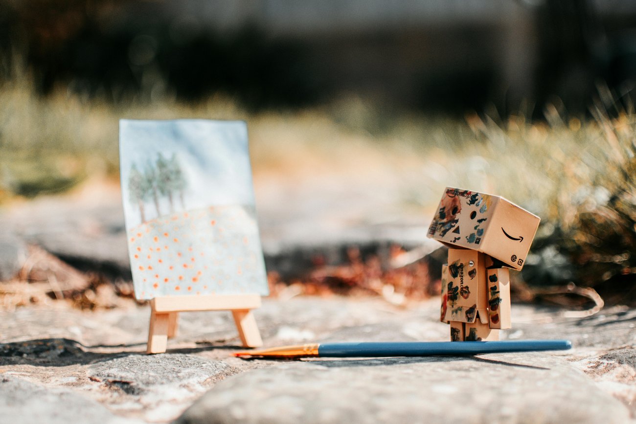 zwei Hände greifen ein Blatt Papier mit einer 3D-Landschaft