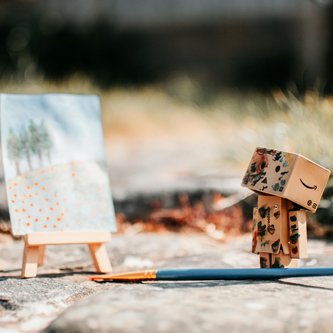 zwei Hände greifen ein Blatt Papier mit einer 3D-Landschaft