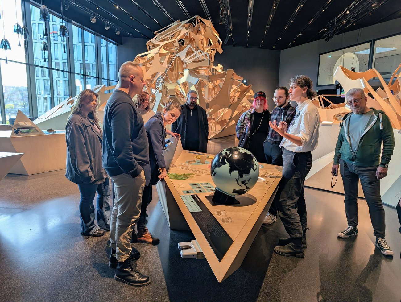 Gruppe von Menschen steht um einen Holztisch mit Austellungsstücken