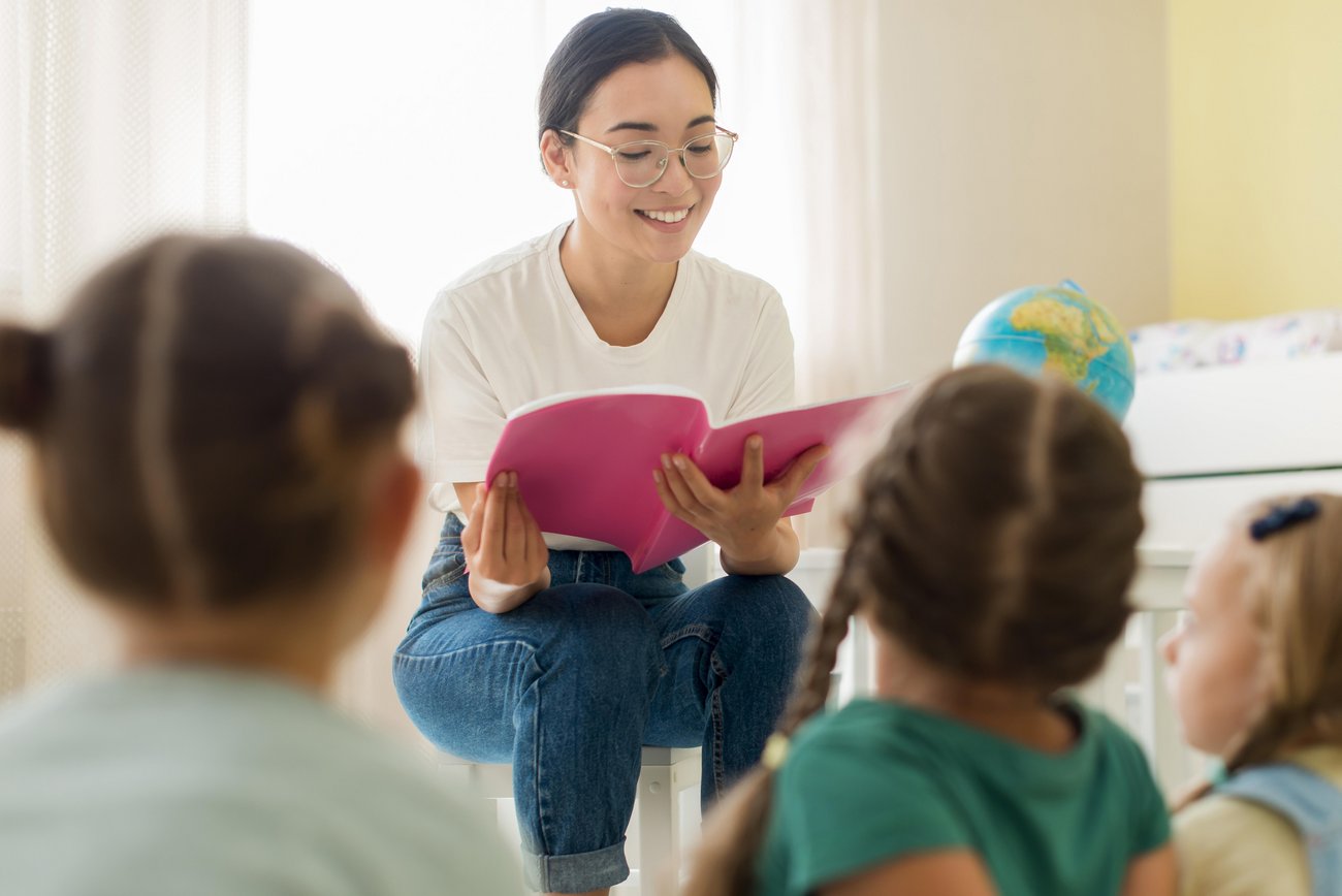Erzieherin übt mit Kindern ABC