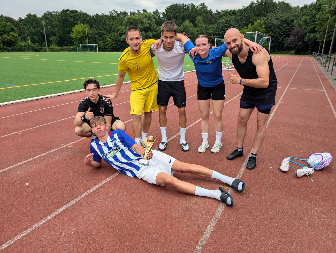 Gruppenfoto der siegreichen Fußballmannschaft auf der Laufbahn