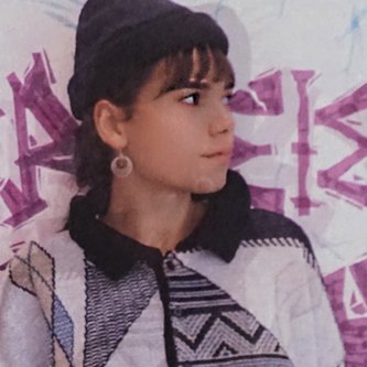 Portrait junge Designerin vor Schriftzugwand 