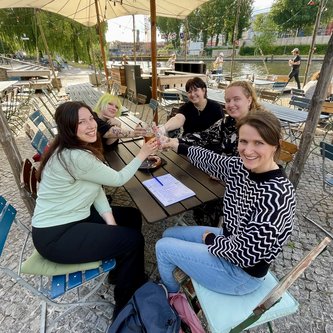 4 ehemalige Schülerinnen und eine Lehrerin stoßen miteinander an