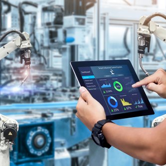 IT-Assistent bedient Maschine mit Tablet