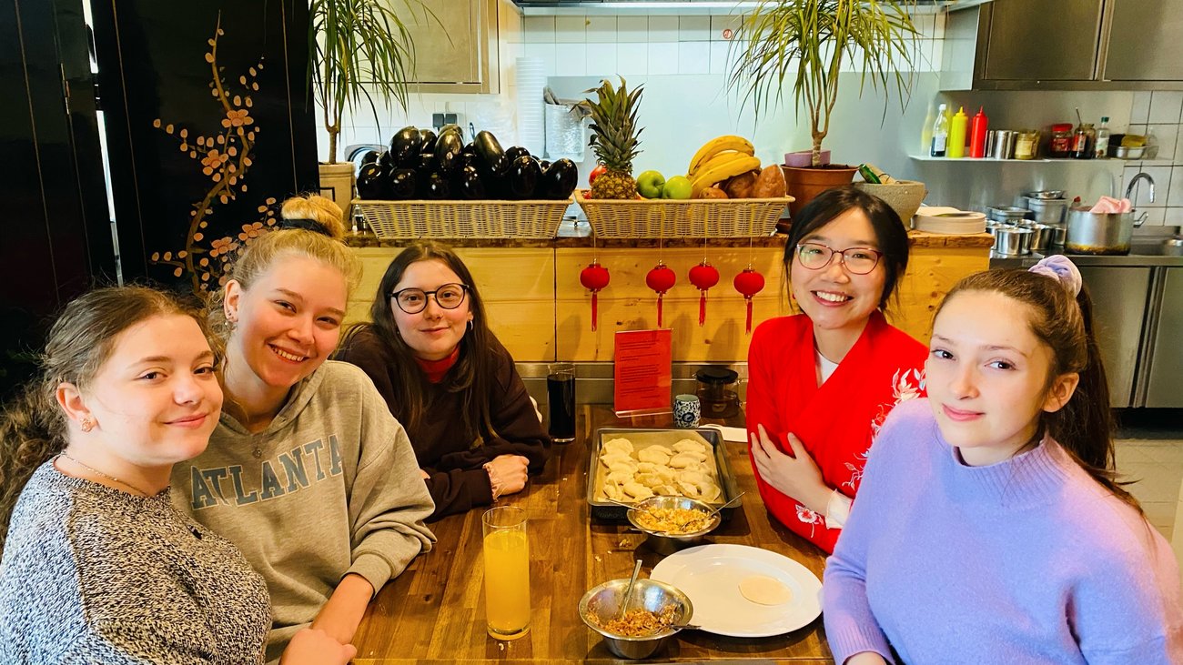 Lehrerin mit vier Schülerinnen in asiatischem Reataurant