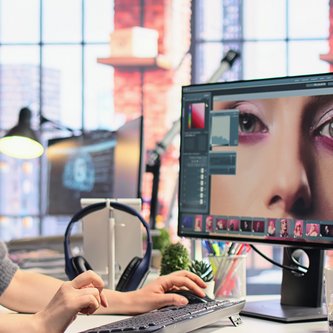 junge Designerin vor zwei Bildschirmen