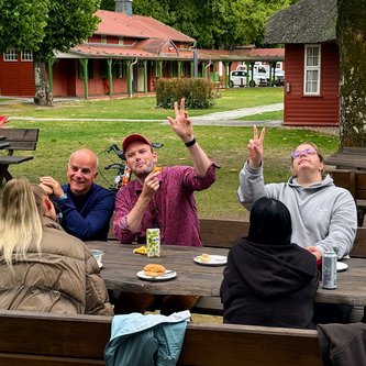 Gruppe von Schülern und Lehrern beim Essen draußen