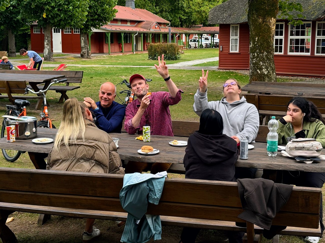 Gruppe von Schülern und Lehrern beim Essen draußen