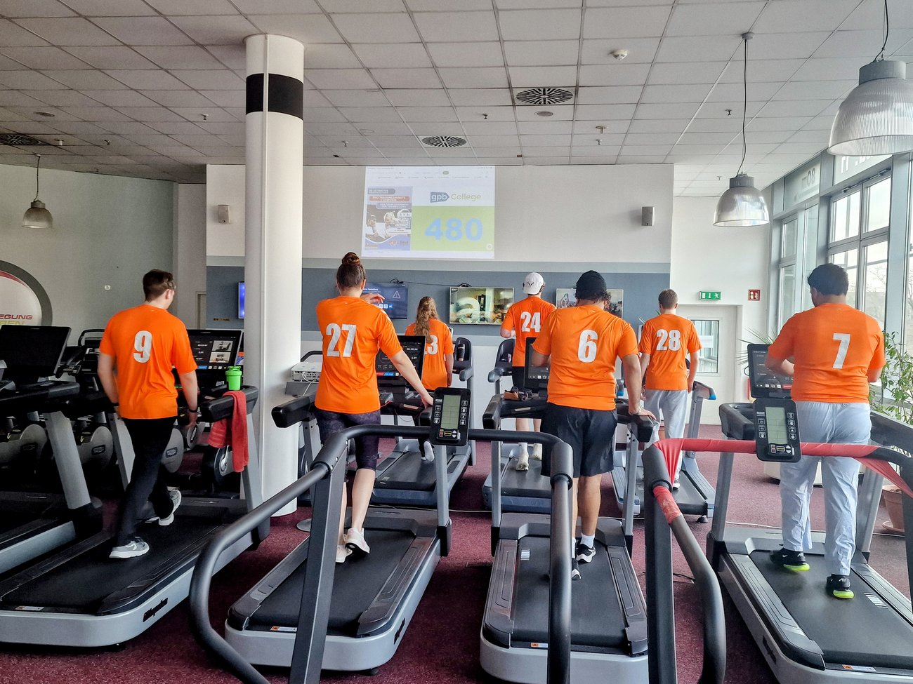 Teilnehmer in orangen Trikots von hinten