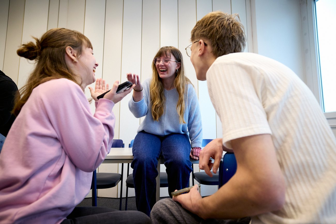 Schüler sitzen auf Tisch und unterhalten sich 
