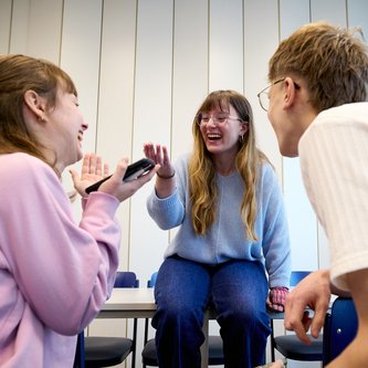 Schüler sitzen auf Tisch und unterhalten sich 