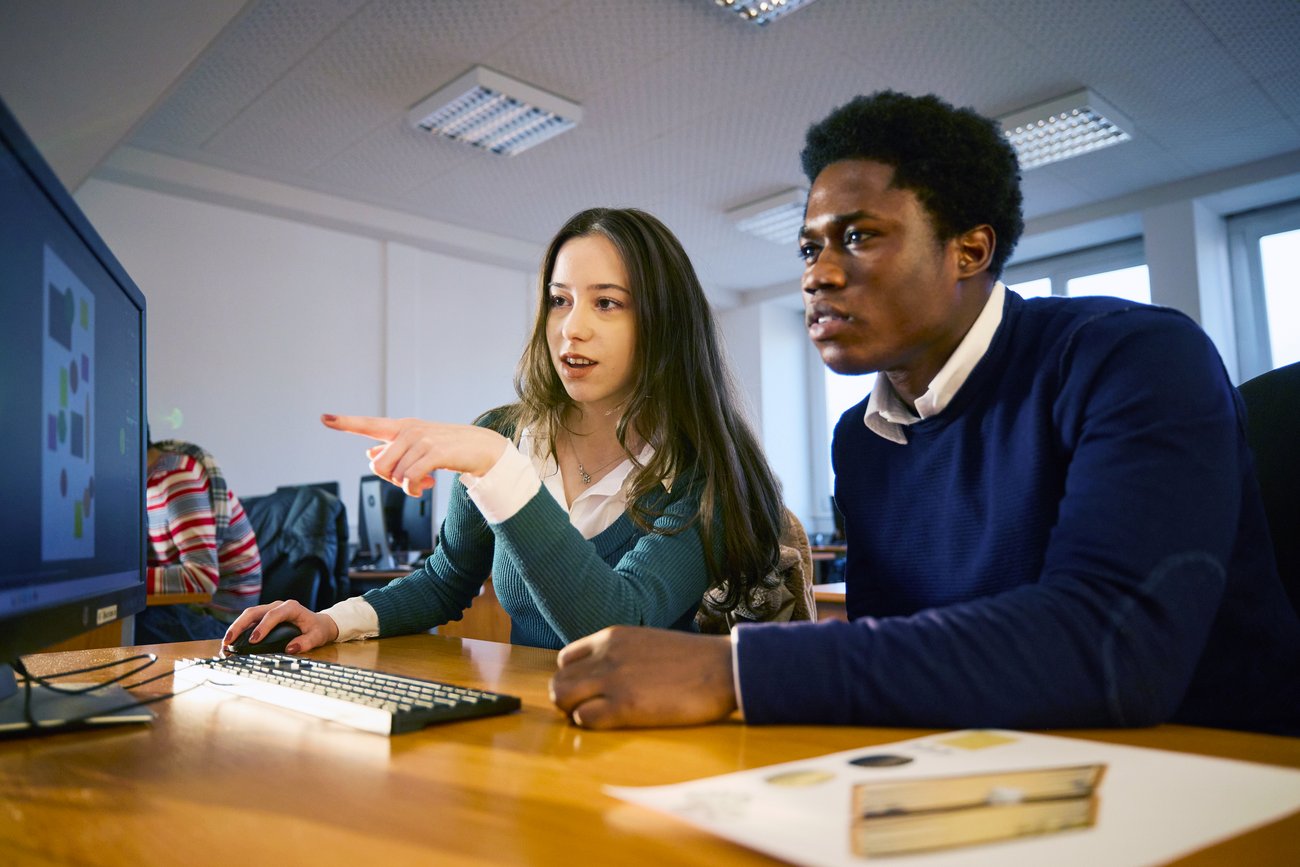 Schüler tauschen sich am Computer aus