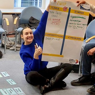 Schülervertreterin hält Plakat hoch