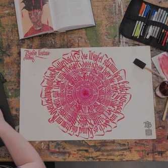 Grafikdesigner bei der Arbeit an Kalligrafie und digitaler Illustration am Schreibtisch