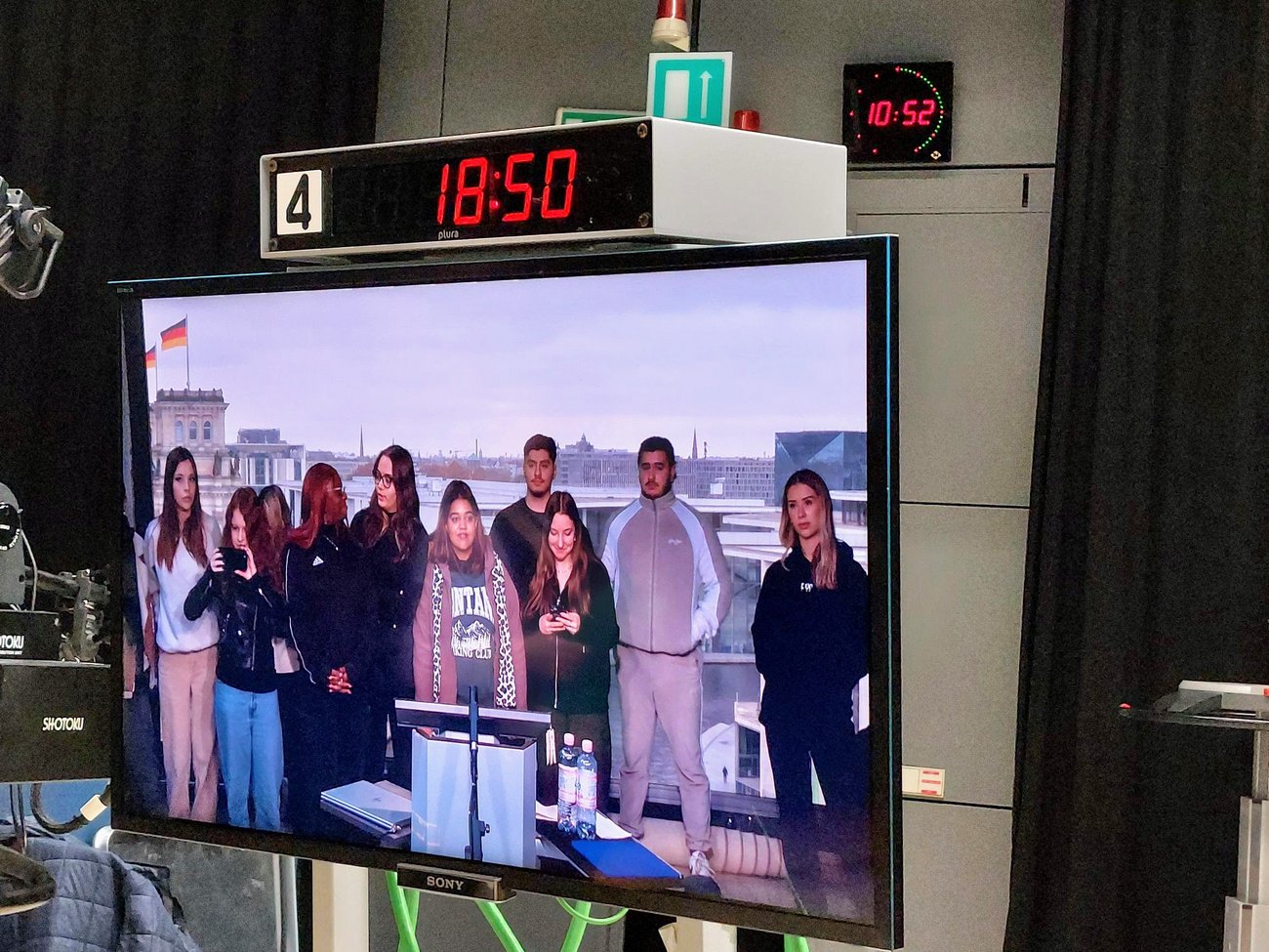 Gruppe von Schülern vor einem großen Bildschirm