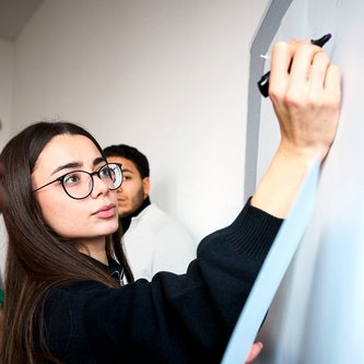 Schülerin schreibt an Tafel