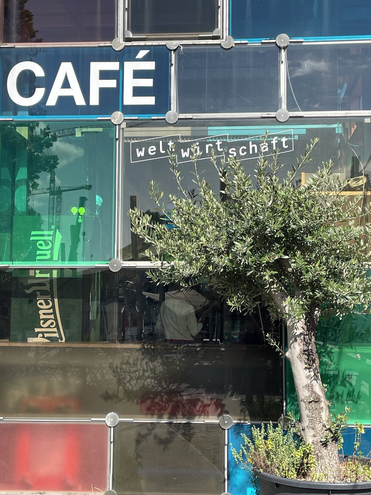 bunte Glasfenster mit Aufschrift Café Weltwirtschaft