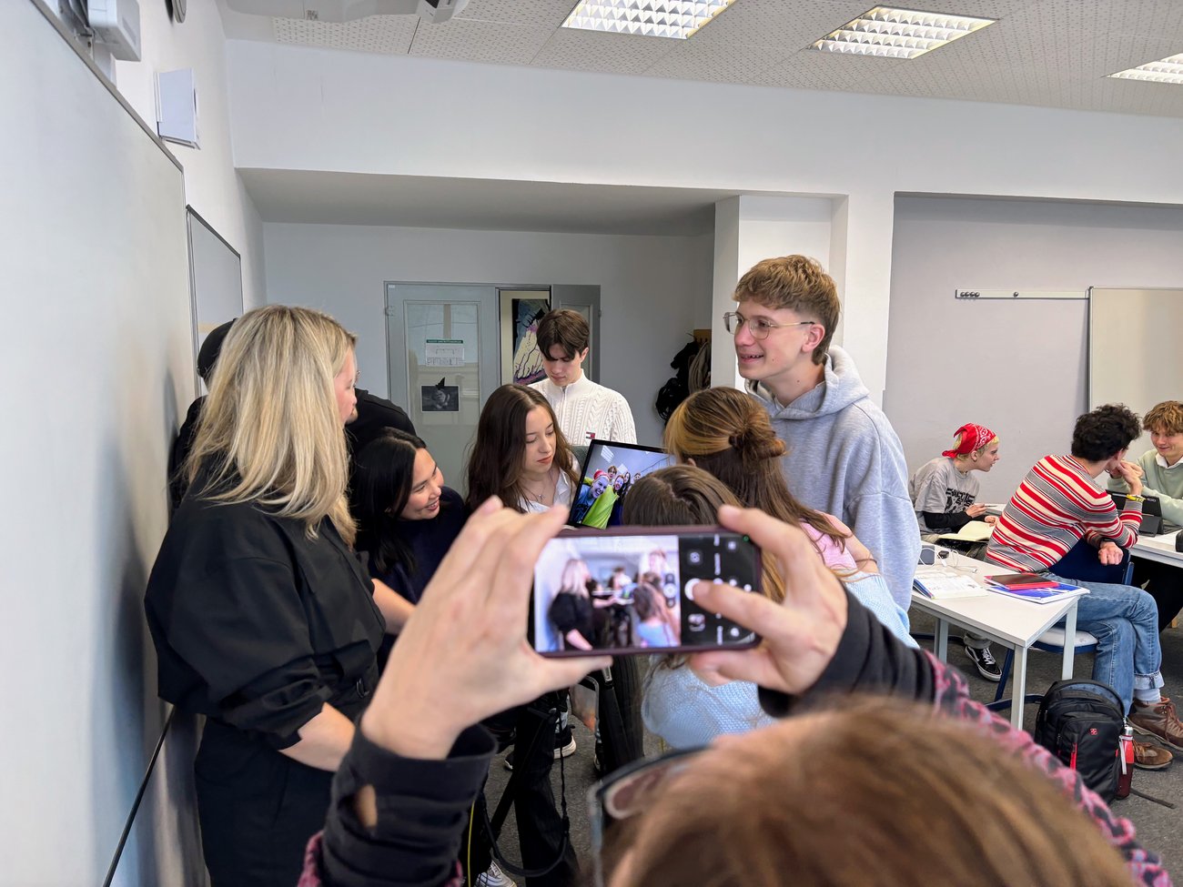 Jemand fotografiert mit einem Handy die Fotografin