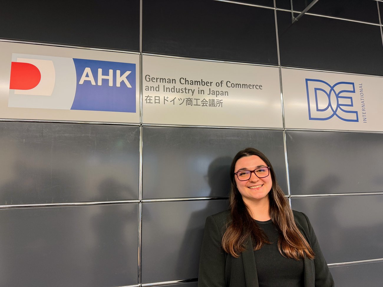 Junge Frau steht vor einer Wand