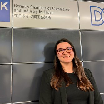 Junge Frau steht vor einer Wand