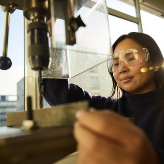 Mädchen an Ständerbohrmaschine