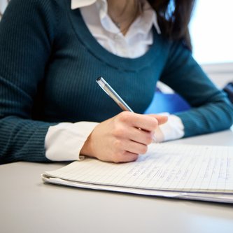 Schülerin schreibt am Tisch