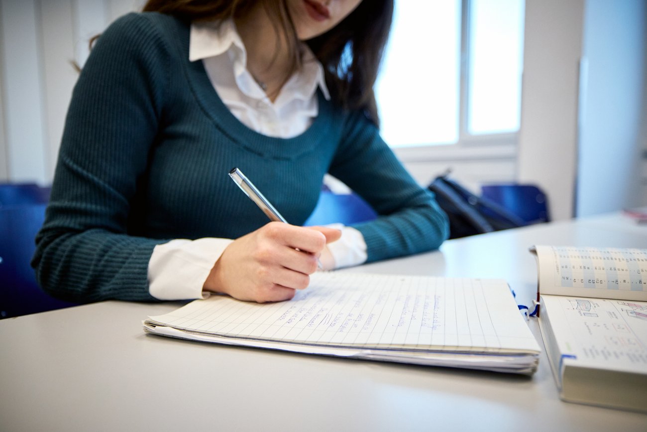 Schülerin schreibt am Tisch