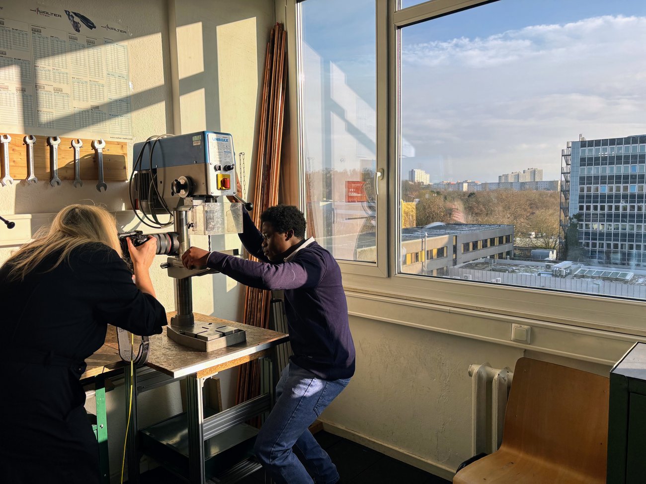 Fotografin mit Schüler an der Bohrmaschine