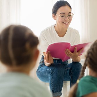 Erzieherin übt mit Kindern ABC