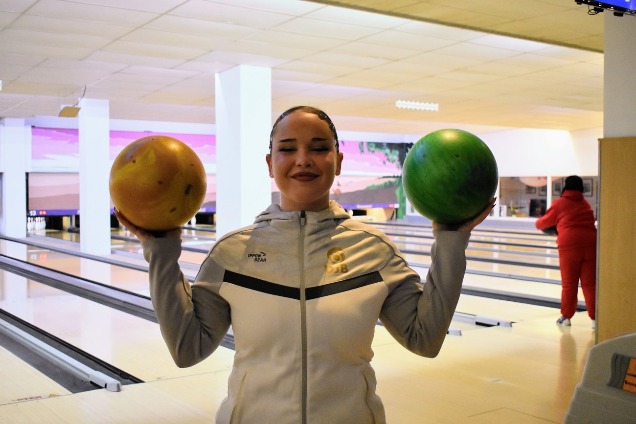 Schülerin mit zwei Bowlingkugeln
