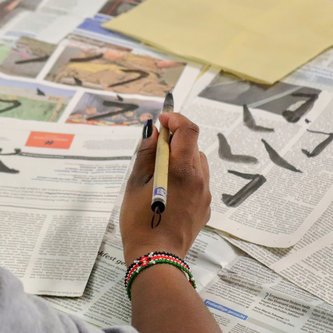 Schülerin von hinten mit Pinsel in der Hand