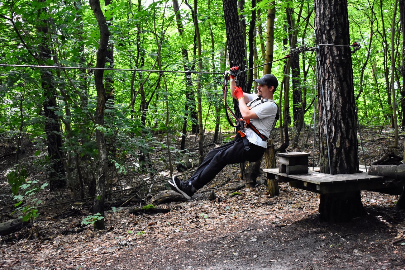 ein Schüler an der Seilrutsche im Kletterwald