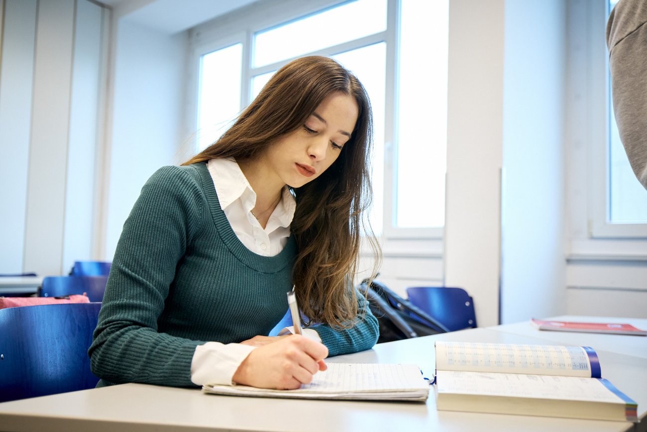 Schülerin schreibt am Tisch