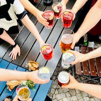 verschiedene Getränke werden über den Tisch gehalten