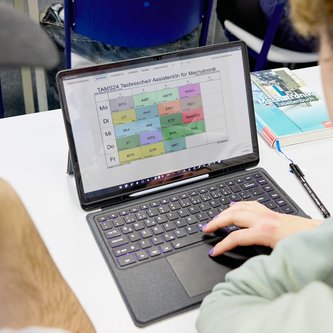 Schüler schaut auf Stundenplan am Tablet