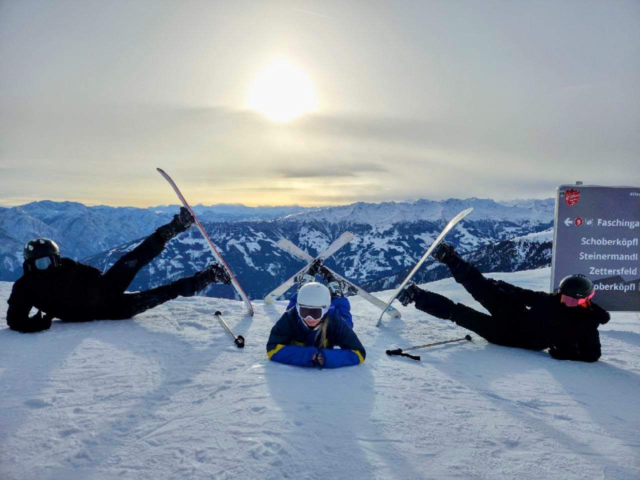 Drei Skifahrer liegen im Schnee mit Sonne